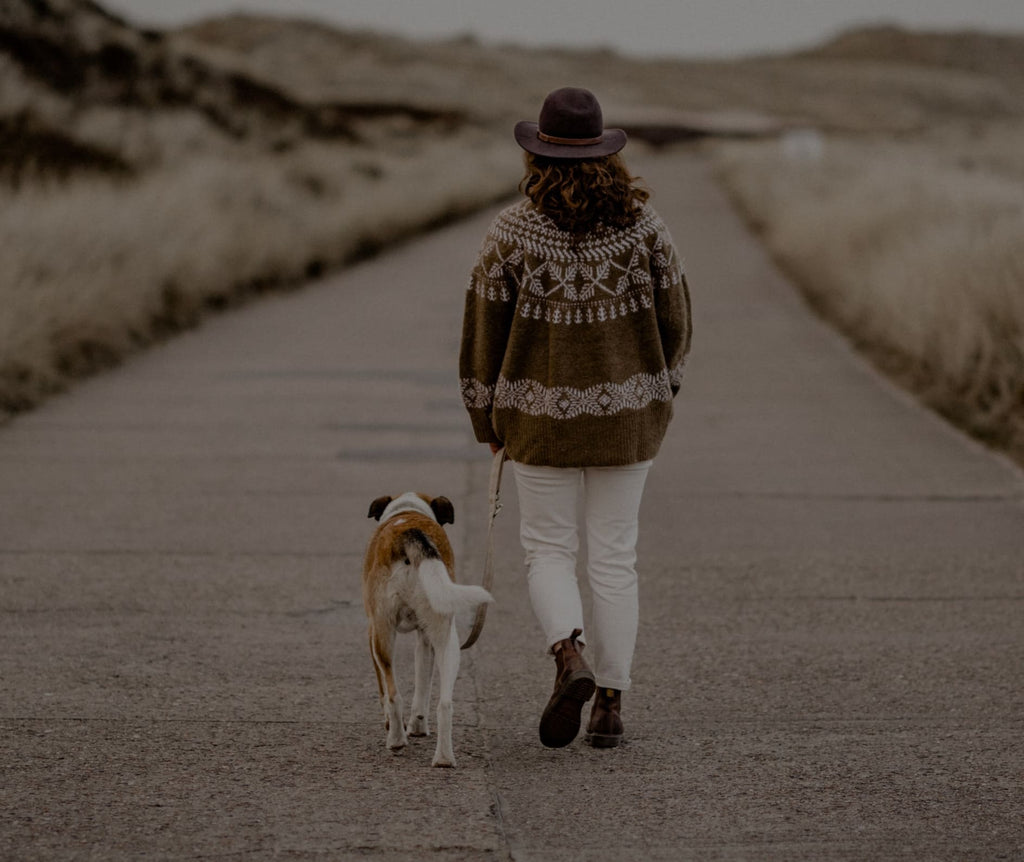 Frau läuft mit Hund und einer Boho Hundeleine am Strand entlang